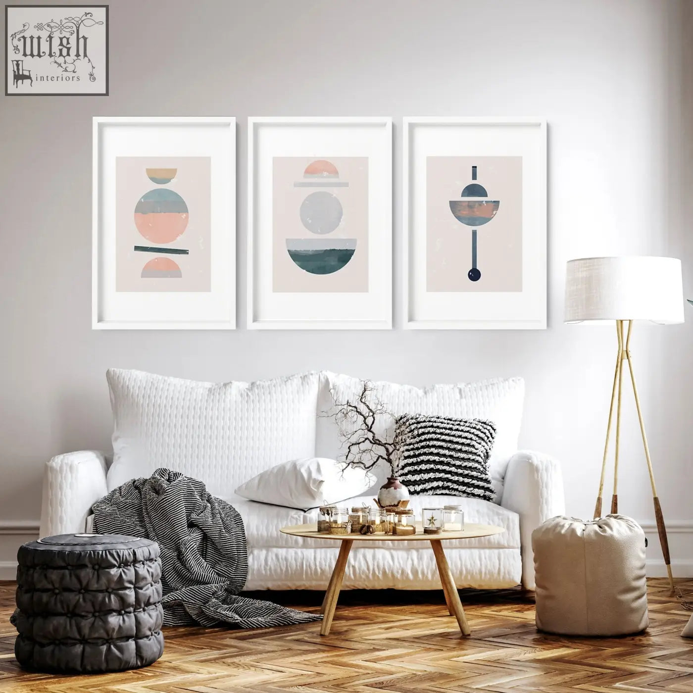 Three framed abstract art prints with geometric shapes in muted pastels hanging above a white sofa in a living room