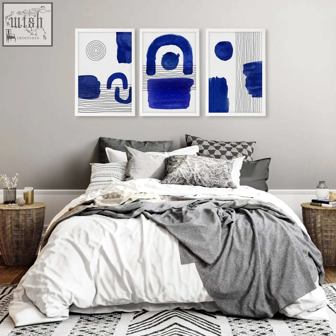 Three framed abstract wall art prints with bold blue brushstrokes and geometric patterns above a bed