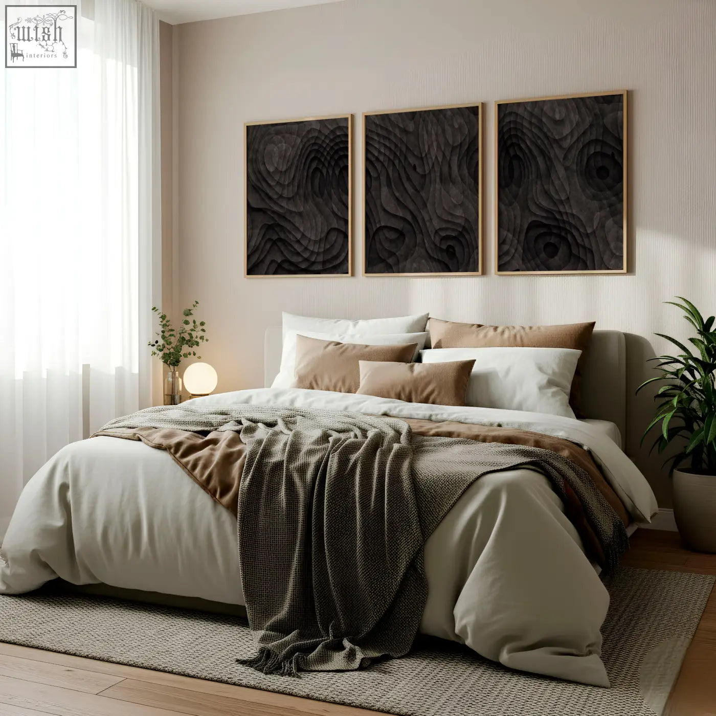 A cozy bed with soft beige and brown linens and a textured gray throw next to abstract artwork dark charcoal topographic wave prints