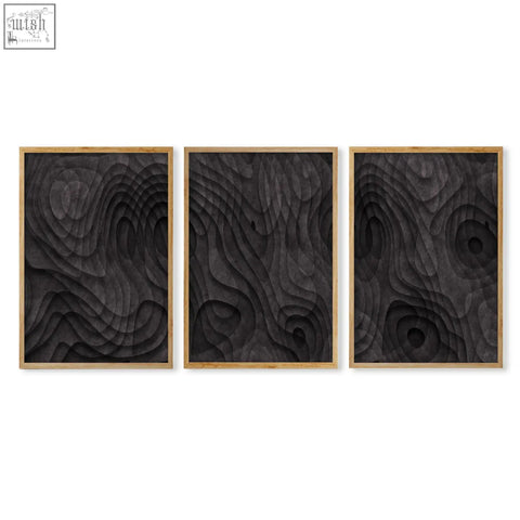 Set of three black wood relief abstract artwork panels with dark charcoal topographic wave design in light wooden frames