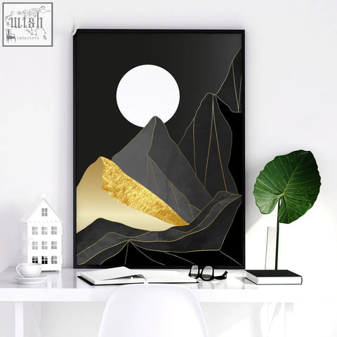 Black-framed minimalist wall art prints featuring stylized dark gray mountains with textured gold accents and a white moon
