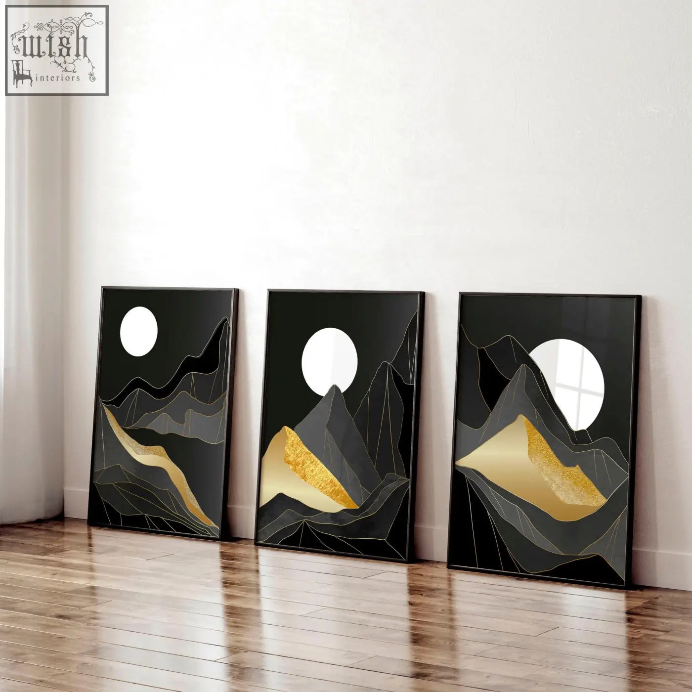 Three minimalist black-framed abstract landscape wall art prints with white moon and gold leaf accents on dark gray peaks