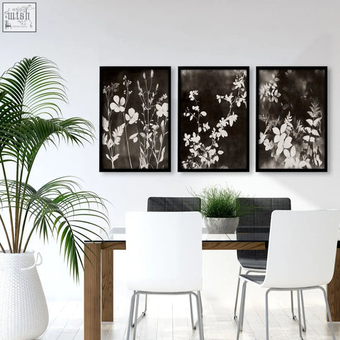 Three framed black-and-white abstract nature art botanical prints hang above a dining room table