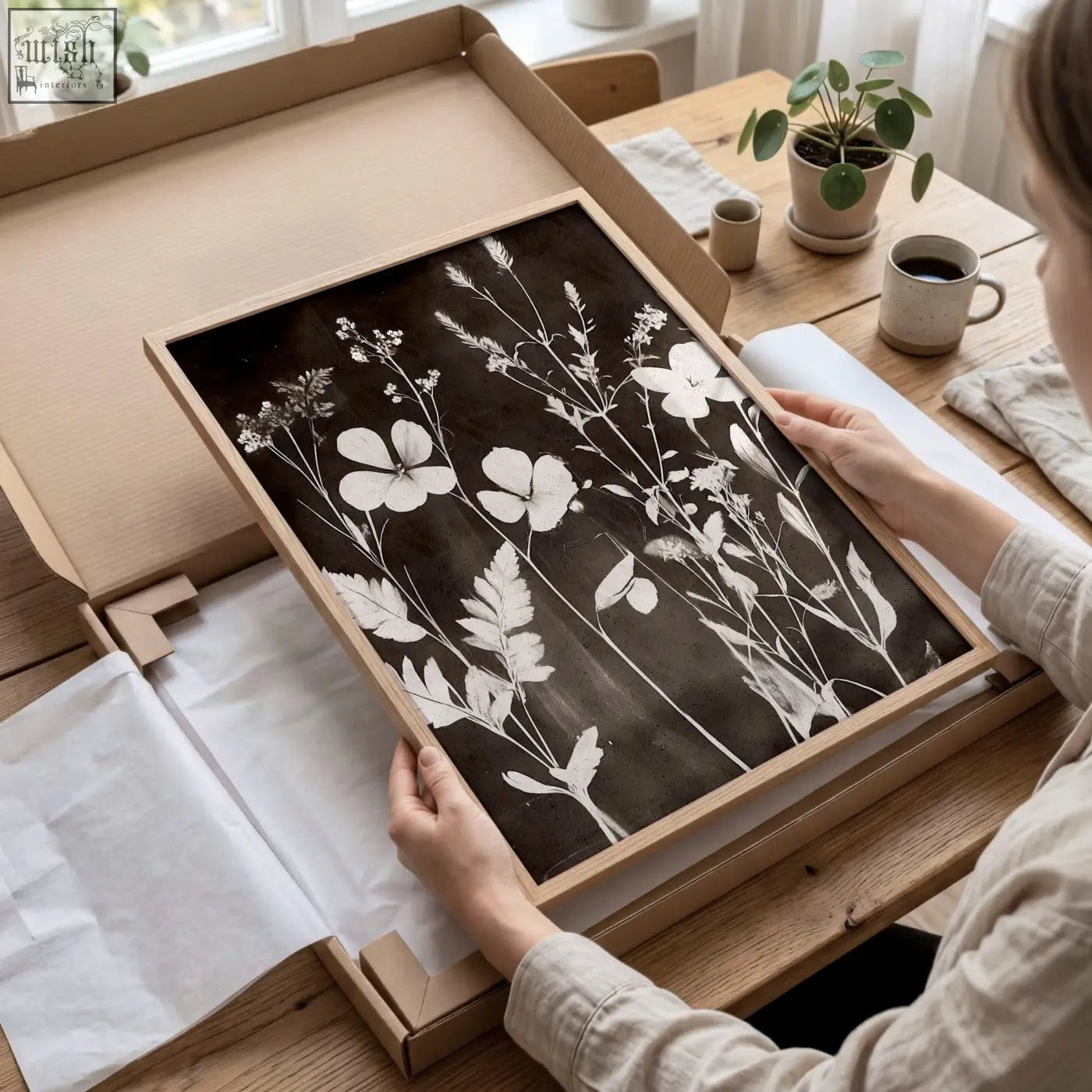 A rectangular wooden-framed abstract nature art print with white floral silhouettes on dark background for dining room