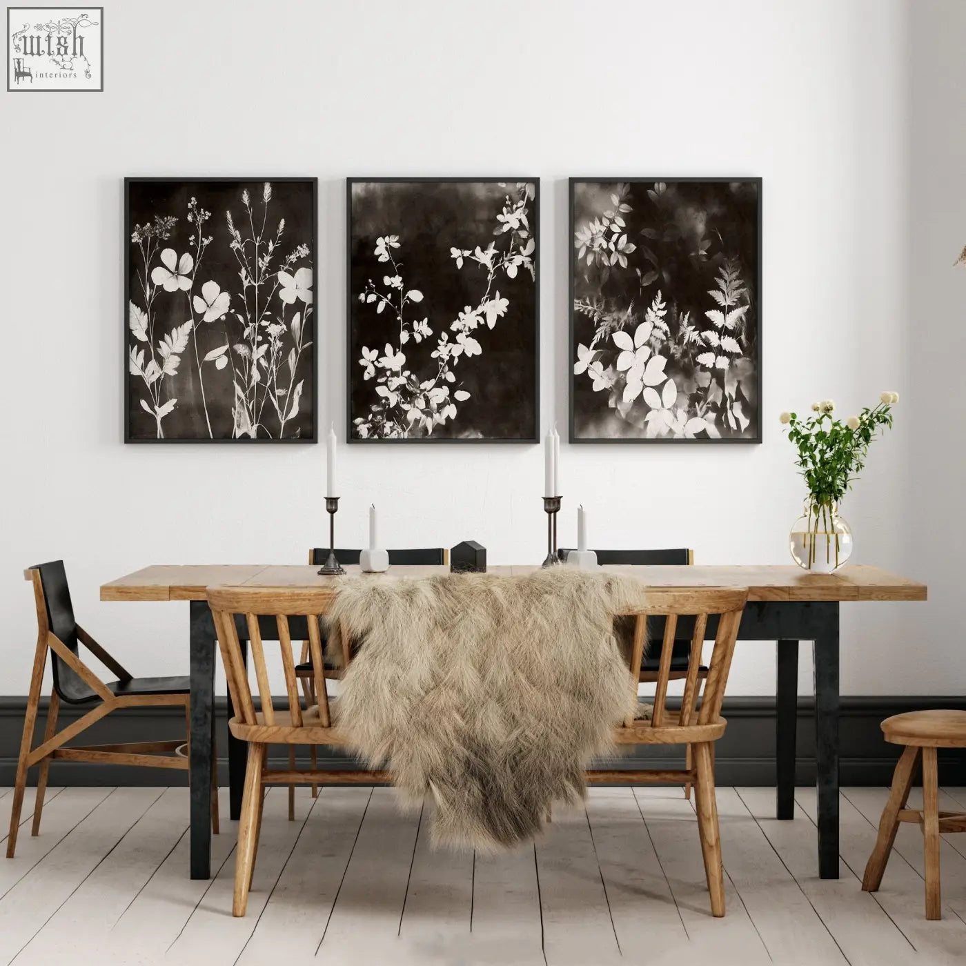 Three black-framed abstract nature art botanical prints with white floral silhouettes hanging above a dining room table