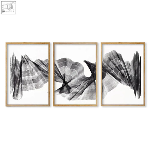 Set of three framed abstract painting art prints with flowing black and white wave line art in thin wood frames