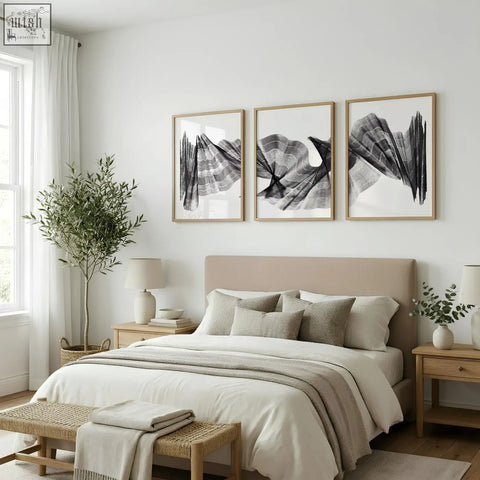 Beige upholstered bed with matching pillows and neutral throw complemented by abstract painting art print set of 3
