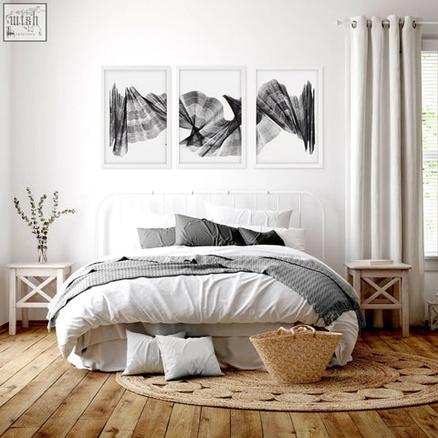 Woven wicker basket with natural tan hue and sturdy handles beside abstract painting art print charcoal flowing textured wave set of 3