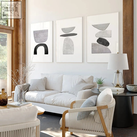 Set of 3 wall art prints featuring minimalist abstract black and white stacked stone shapes with white frames
