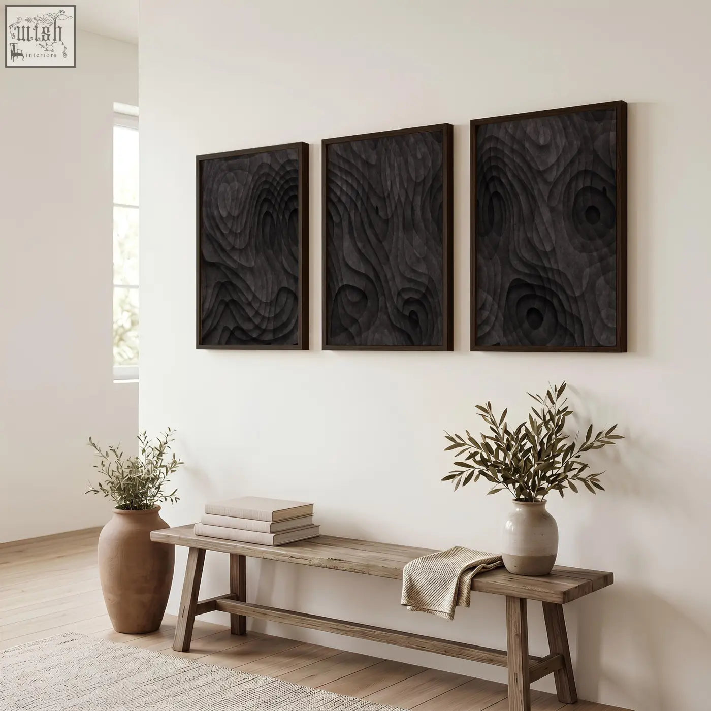 Three dark charcoal topographic wave abstract paintings with raised swirling texture in wood frames on white wall