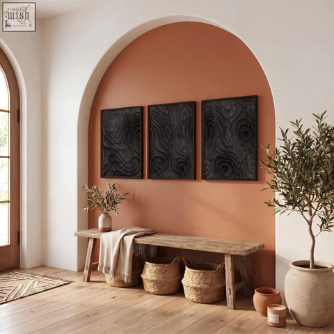 Three black framed wood grain abstract painting prints featuring dark charcoal topographic wave texture on terracotta wall