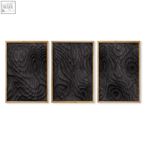 Set of three framed black wood relief art pieces with dark charcoal topographic wave texture in light wood frames