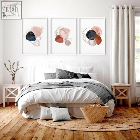 Woven wicker basket with natural tan hue and sturdy handles paired with abstract wall art prints for bedroom decor