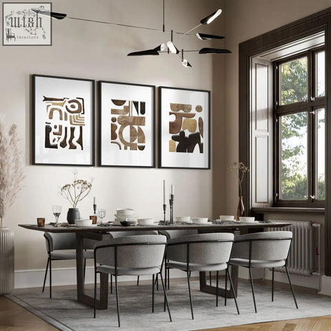 Three framed abstract wall art prints with geometric patterns in earthy brown beige and black above dining table