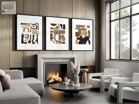 Three framed abstract wall art prints with geometric patterns in earthy brown and black tones above a fireplace