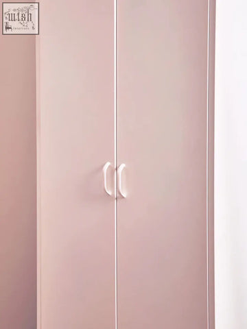 A sleek pastel pink wardrobe with minimalist white handles styled like the academy white two-door locker style