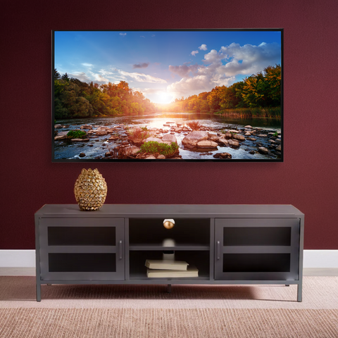 A sleek grey metal media unit with two glass-paneled doors and open shelving for stylish storage