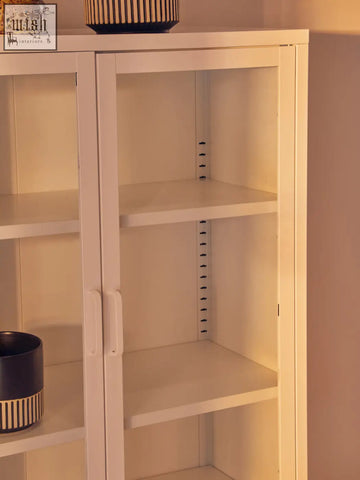 Acier two door white metal cabinet with glass doors and adjustable shelves in a sleek white metal design