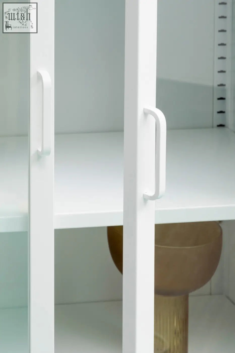 Acier two door white metal cabinet with glass doors featuring sleek minimalist handles and clean lines