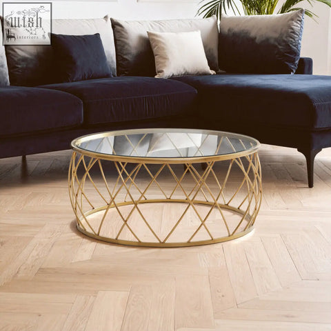 Ackley gold round coffee table with a gold-toned geometric metal frame and clear glass top for stylish living spaces