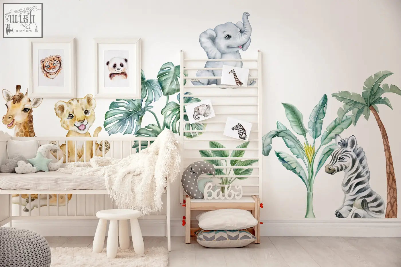 A white wooden crib with a soft blanket next to adorable safari wall decals and african animals stickers for kids room