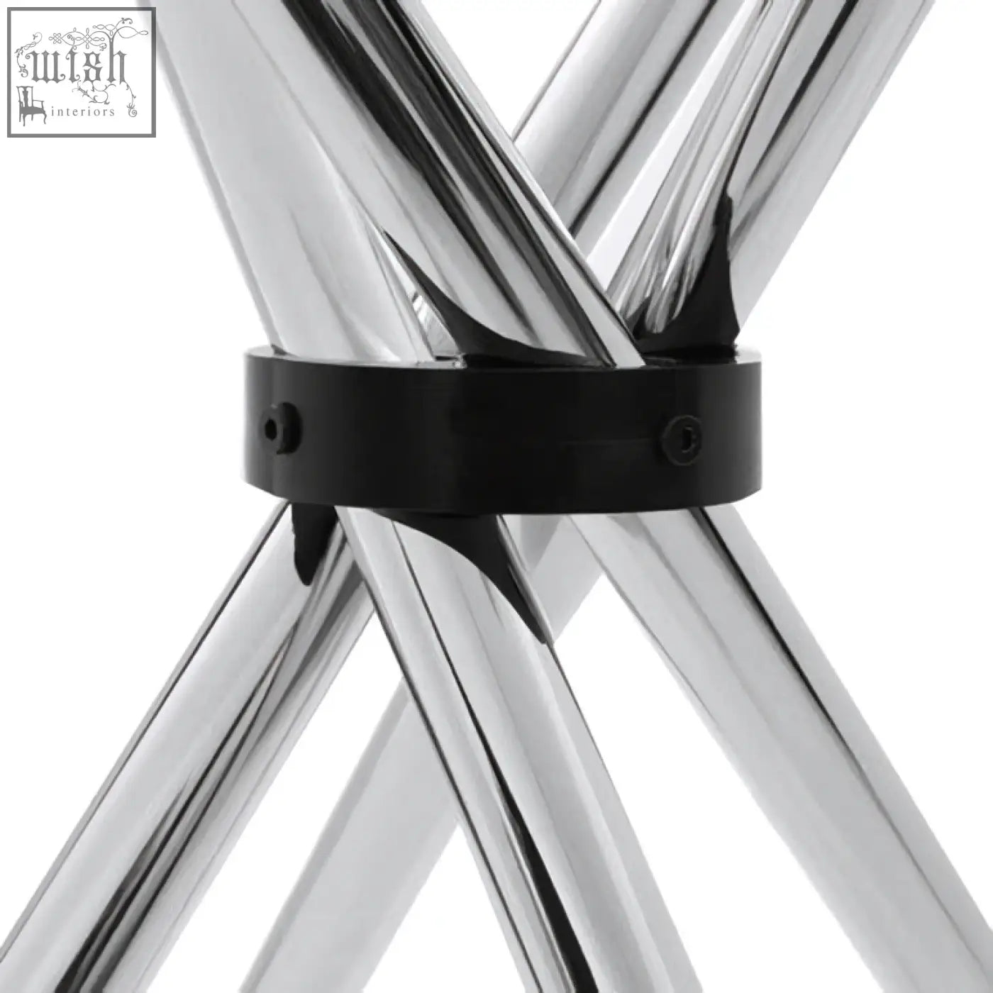 Chrome finished metal folding stool with black clamp on intersecting legs shown near afton round dining table with cross base