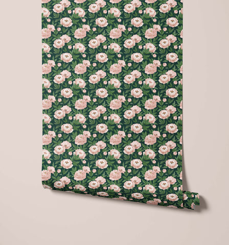 A roll of agatha dark green peony wallpaper with a dense pattern of soft pink peonies and lush green leaves