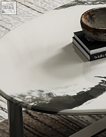 A sleek agatha nesting coffee table with a glossy white oval top featuring a black and gray marble pattern