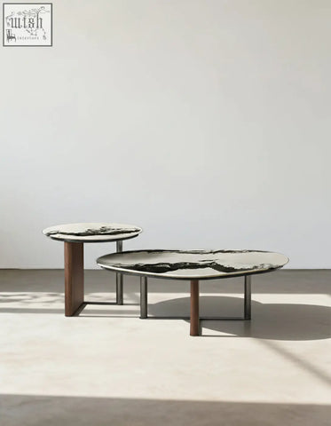 Two agatha nesting coffee tables with black and white marble tops and slender wooden legs in a minimalist style