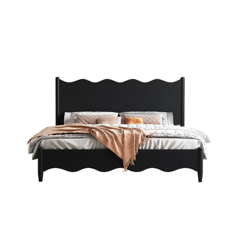 Black agatha queen size storage bed with scalloped headboard and footboard dressed in gray linens and peach throw blanket