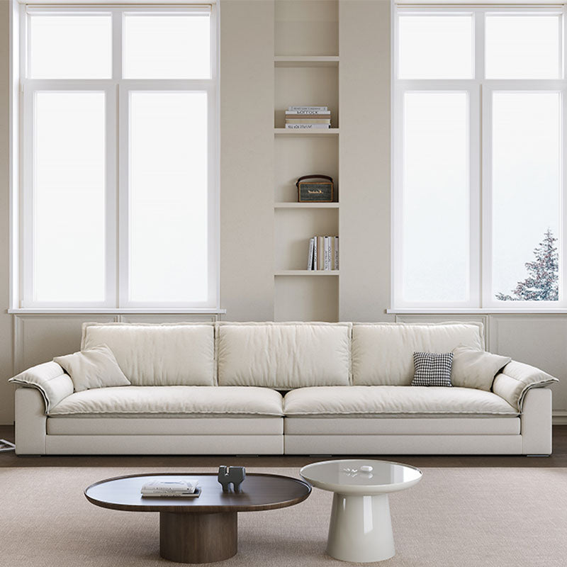 Cream-colored leather aiden sailboat two seater sectional sofa with modern lines and plush cushions in suede