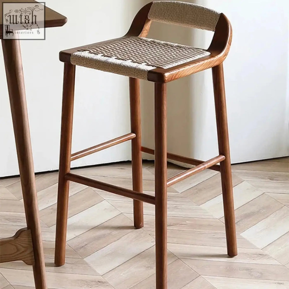 Aiko bar stool with solid ash wood frame, warm walnut finish, and woven natural fiber seat and backrest