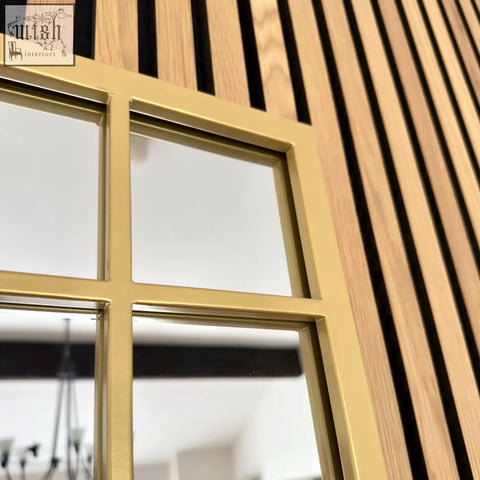 Aimi gold metal rectangle window mirror with four rectangular panes set against vertical wood slats