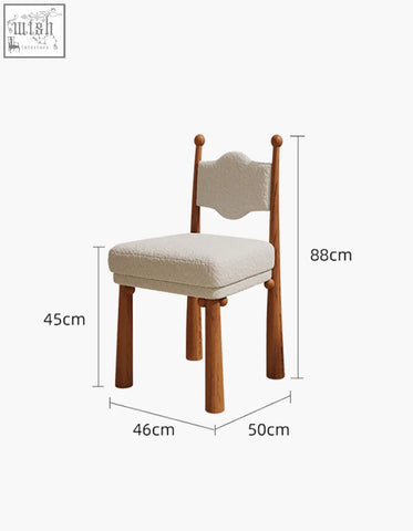 A cozy cream ainsley dining chair with textured fabric seat and backrest supported by sturdy wooden legs and posts