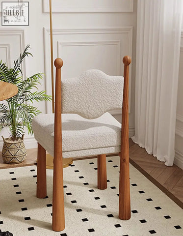 Ainsley dining chair features a cozy white textured cashmere seat with wooden baseball bat legs and rounded finials