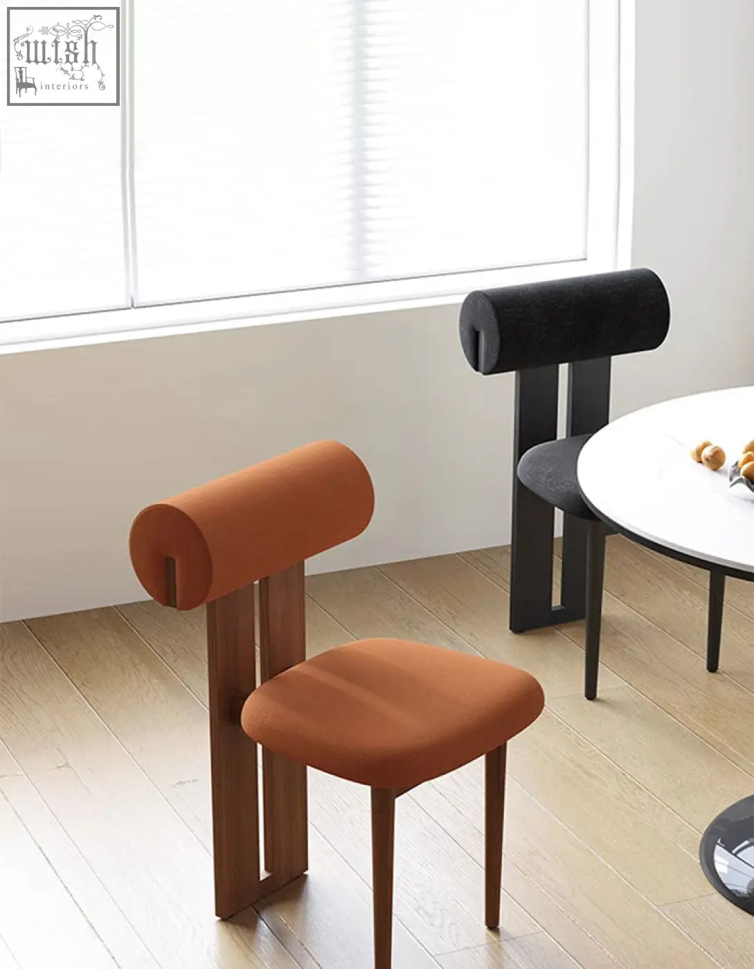 Airelle dining chair in black with modern orange upholstered seat and wooden legs for stylish dining areas