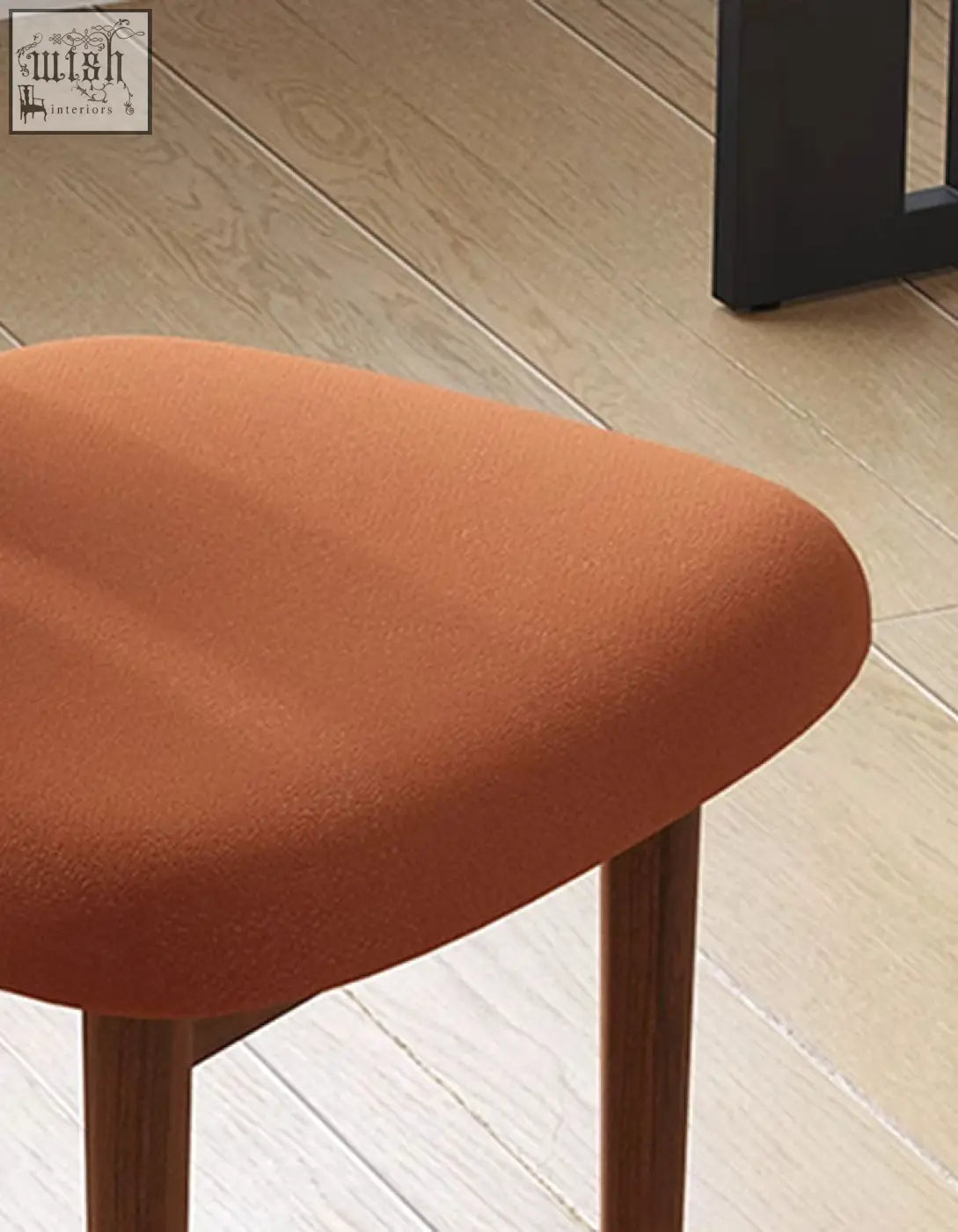 Airelle dining chair with a soft rust-colored upholstered seat and slender wooden legs perfect for dining areas