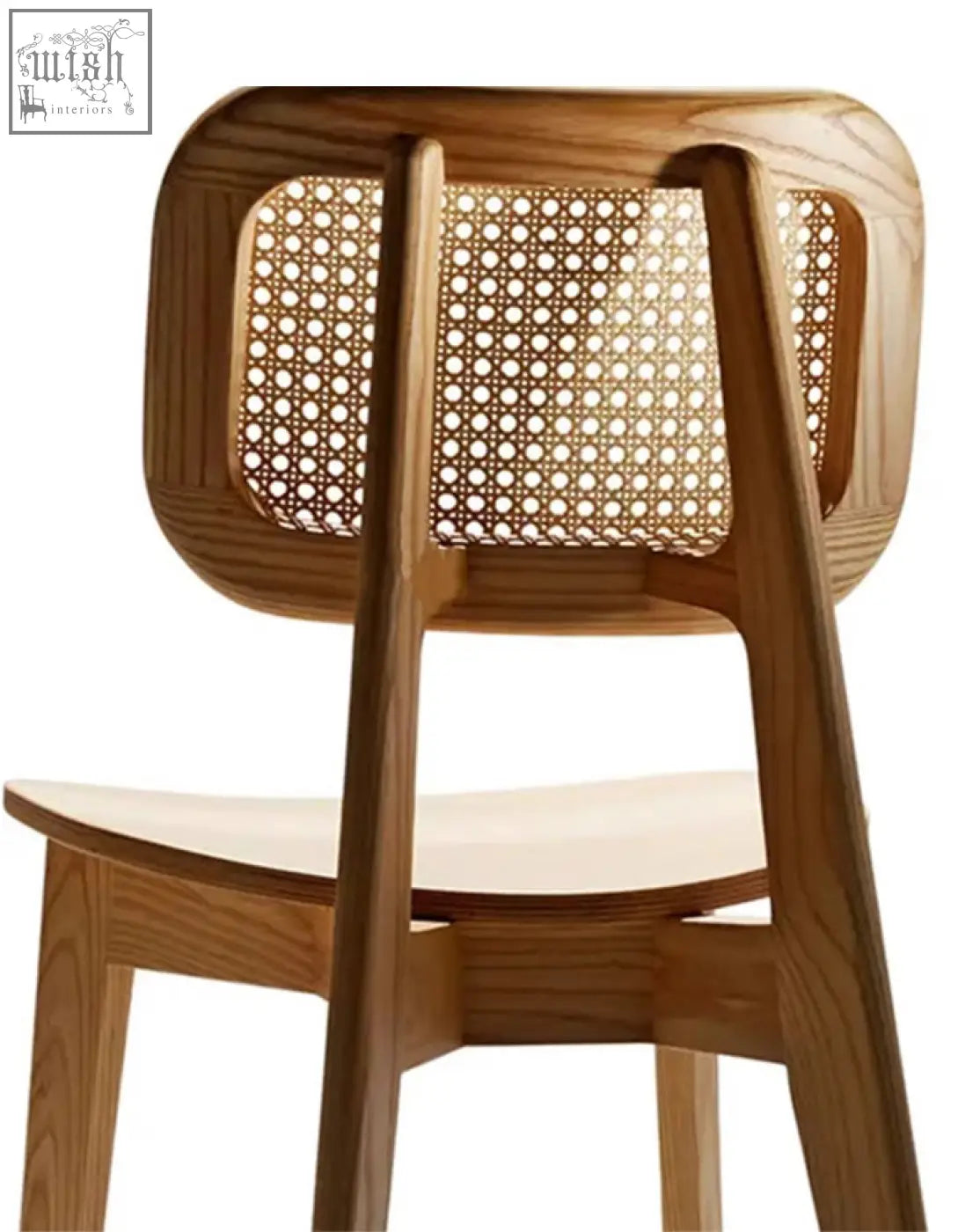 A light wood aislin rattan dining chair with a curved frame and woven rattan back as a dining chair