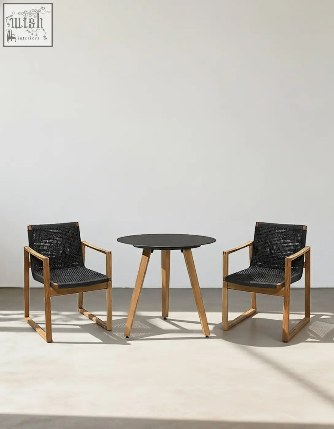 Modern outdoor dining set with round black tabletop, wooden legs, and light wood chairs with woven seats perfect for outdoor dining