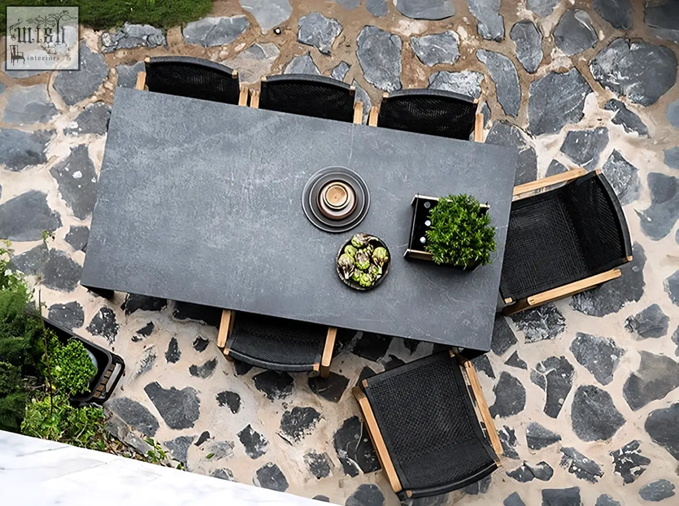 Aisulu 6 seater outdoor dining set with modern dark gray stone table and black woven chairs with light wood legs