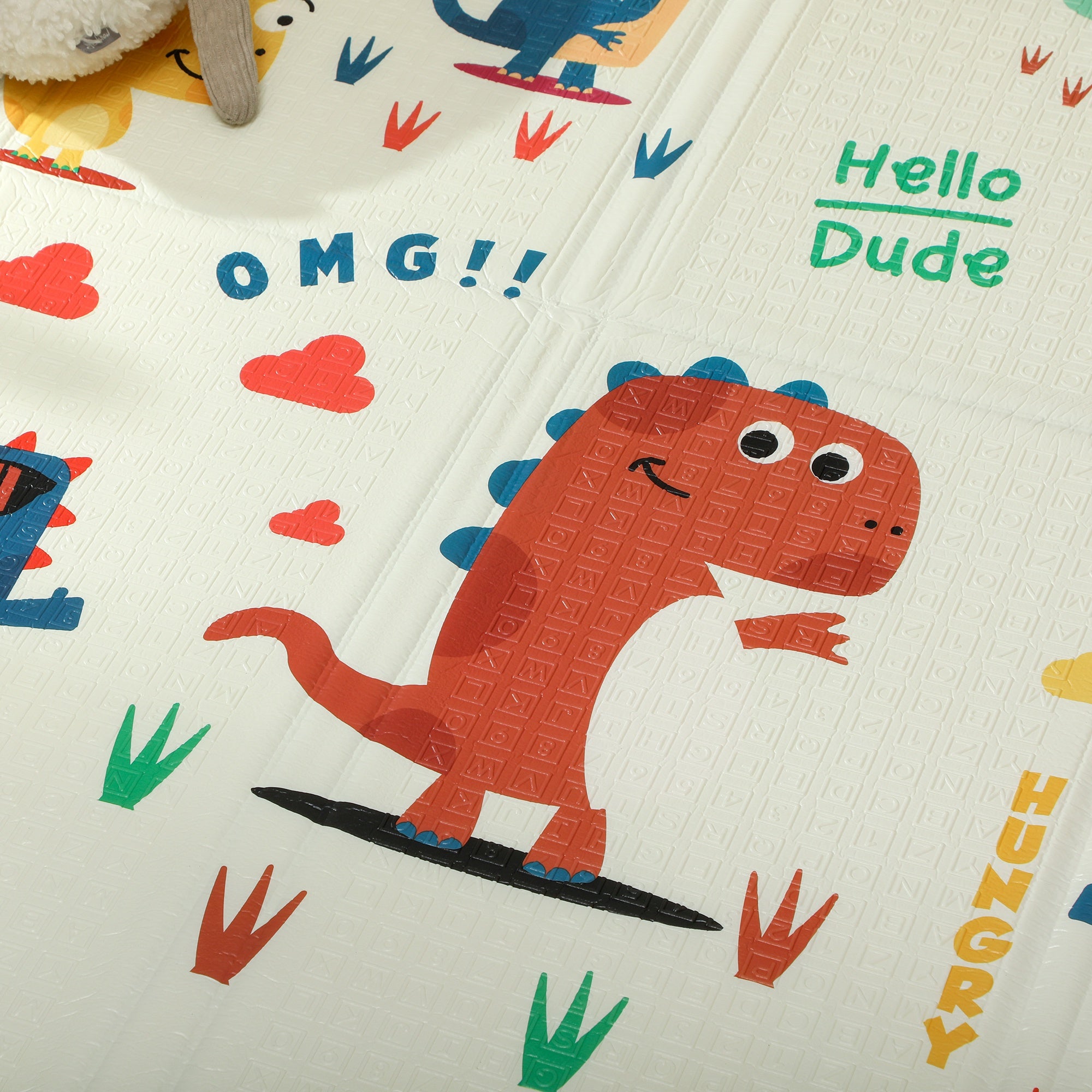 A cheerful orange dinosaur print on a foldable aiya play double sided baby play mat creating a safe space for baby play