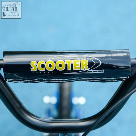 Black padded handlebar grip with yellow scooter logo and stitched edges on aiyaplay kids scooter with rear brake