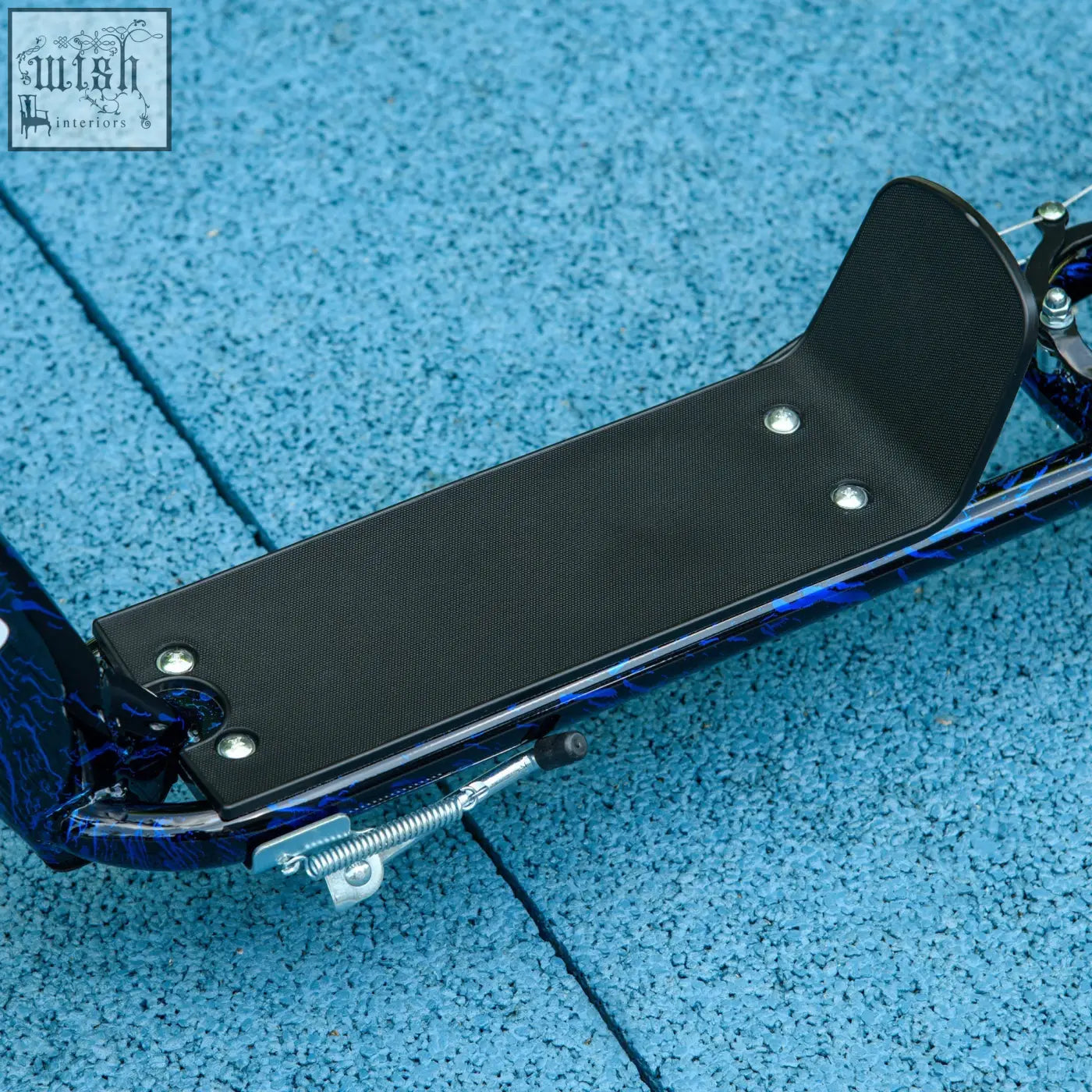 Black textured footplate with silver screws on blue black patterned aiyaplay kids scooter with rear brake