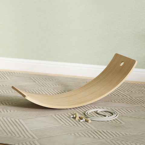 Light-colored wooden kids balance board with smooth curved surface and rounded ends for sensory play and wobble fun