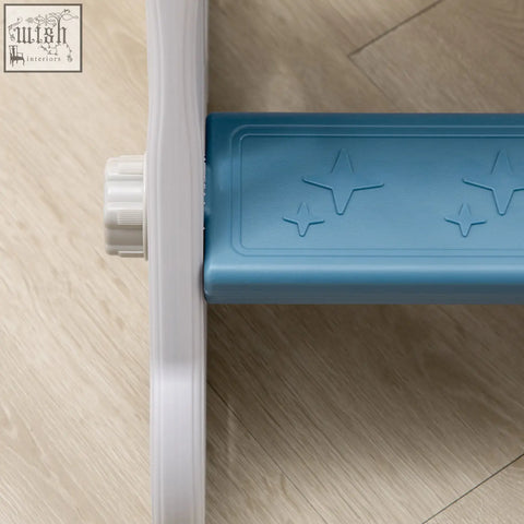 Blue plastic step with star-shaped embossments on a space themed kids slide buffer zone for toddlers