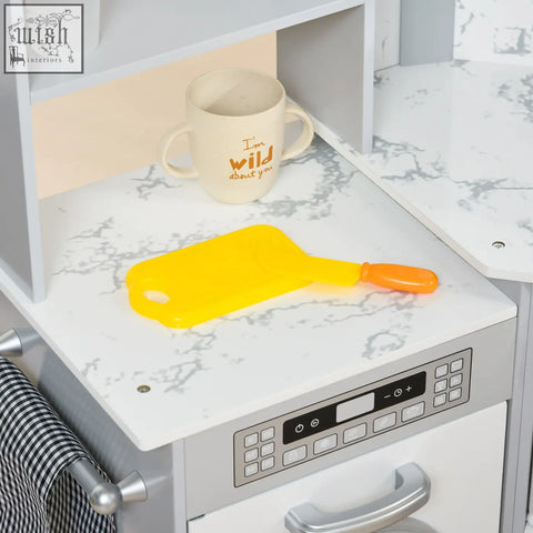 Bright yellow plastic cutting board with orange handle on marble countertop in aiyaplay kitchen playset with water dispenser