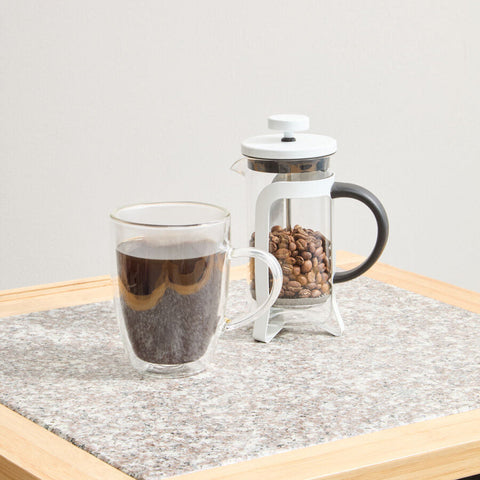 Clear double walled glass mug filled with dark coffee next to akeala matte white cafetiere 350ml for stylish brewing
