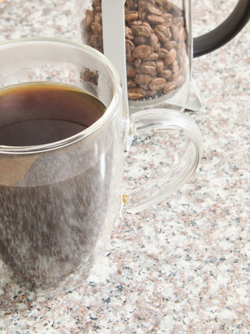 Clear double-walled glass mug with dark coffee paired with matte white akeala matte white cafetiere 350ml