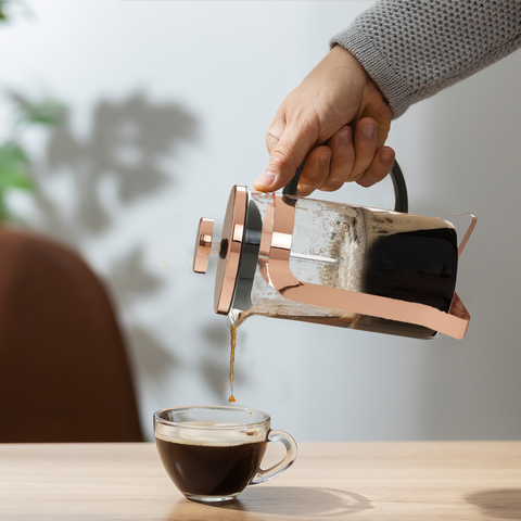 Akeala rose gold cafetiere 350 ml pouring dark coffee from a rose gold french press with clear glass and black handle