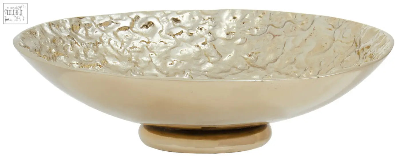 A gold textured round metal bowl with hammered finish and small pedestal base perfect for decor or serving